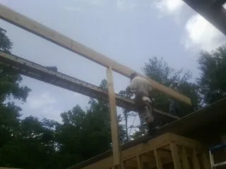 Carpenter setting a ridge beam over a new addition frame — Ice Dam Removal by Roofing Brothers in Nyack