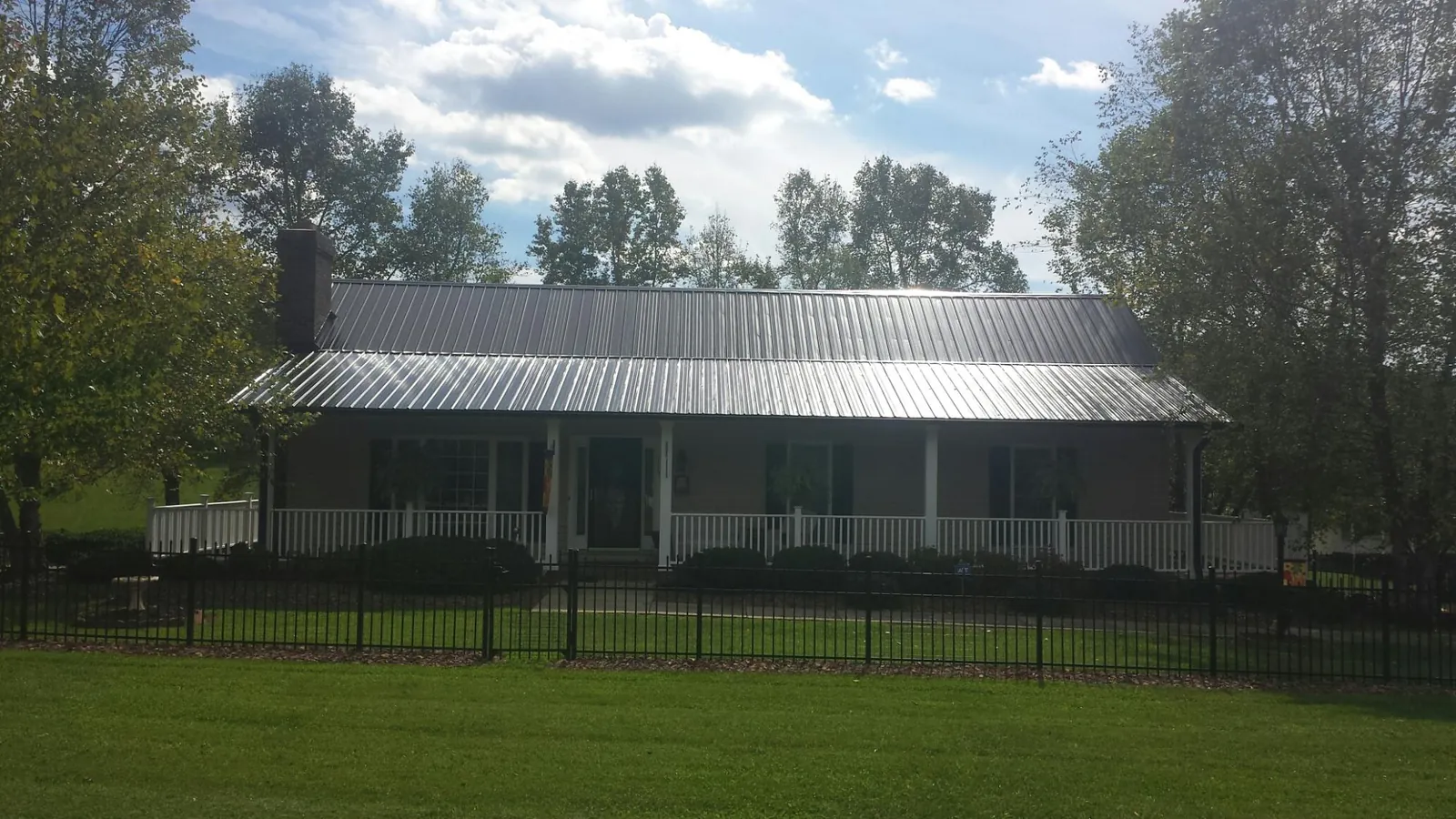 Gray metal roof on a brick ranch with a full width front porch — Gutter Guard Installation work by our crew in Nyack