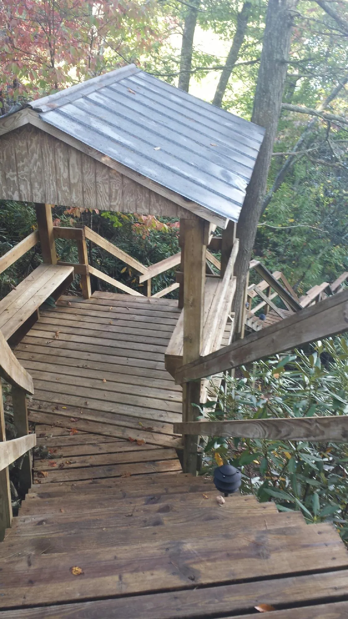 Metal roofed shelter over wooden steps on a wooded walkway — Skylight Repair & Installation work by our crew in Nyack